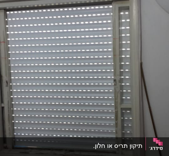 תריסים סגורים עם חריצים לאור בחלון